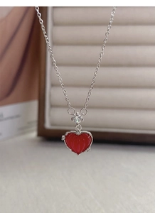 Détail du collier en argent S925 avec pendentif cœur rouge et zircone sur boîte cadeau