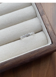 Close-up of S925 sterling silver hollow heart ring displayed in a wooden jewelry box