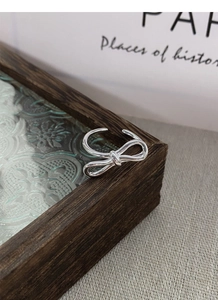 Macro shot of silver bow ring with adjustable open design on a vintage background