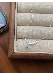 Macro shot of S925 silver necklace featuring cubic zirconia pendant on jewelry tray