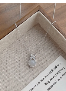 Close-up of S925 sterling silver bow necklace featuring white chalcedony and crystals