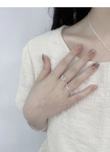 Close-up of minimalist S925 sterling silver hollow heart and twisted rope ring set