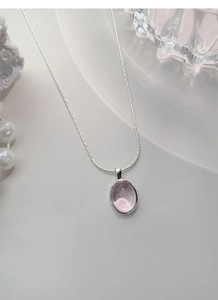 Macro shot of silver necklace featuring an elegant pink oval gemstone pendant