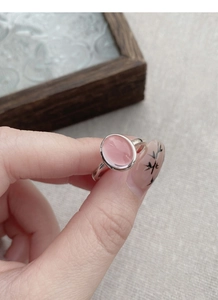 Close-up of a sweet pink oval gemstone ring with a minimalist silver-plated band