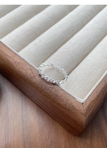 Macro shot of silver open ring with hollow heart chain design in a jewelry box