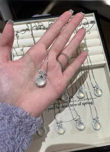 Detail of S925 silver necklace with translucent white chalcedony and bow pendant