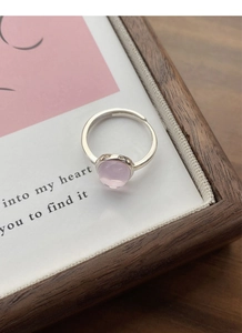 Close-up of S925 sterling silver ring featuring a smooth oval pink gemstone and open band
