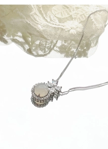 Detailed close-up of S925 silver necklace with white chalcedony and zircon bow pendant