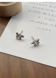 Macro shot of silver dragonfly stud earrings with detailed cubic zirconia wings inlay