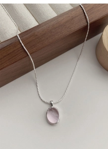 Close-up of S925 sterling silver necklace featuring a pale pink oval gemstone pendant