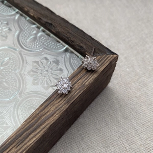 Sparkling S925 sterling silver snowflake stud earrings with cubic zirconia on vintage wood