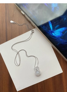 Macro detail of S925 sterling silver bow necklace with translucent chalcedony pendant
