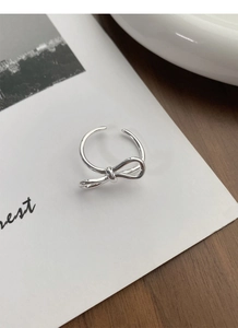 Detailed close-up of a silver S925 sterling silver bow ring with an adjustable open design