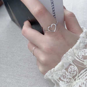 Minimalist S925 sterling silver hollow heart ring on hand with white lace cuff decoration