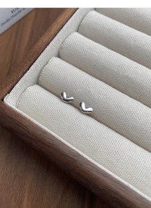 Detailed close-up of S925 sterling silver heart studs in a premium jewelry display box