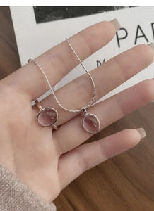 Detailed view of S925 sterling silver set with pink oval gemstones held in hand
