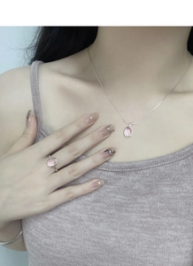 Macro detail of S925 silver necklace and ring set with pink oval crystals on model