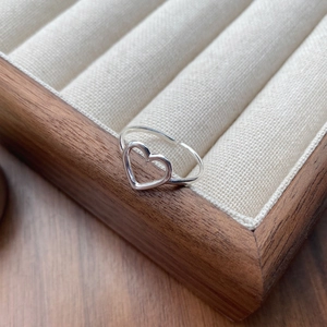 Elegant S925 sterling silver hollow heart open ring on a wooden jewelry display tray