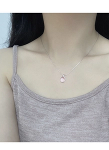 Close-up of S925 silver beaded necklace with an oval pink gemstone pendant on a model