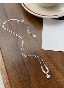 Detail of S925 sterling silver necklace with sparkling round and baguette-cut stones