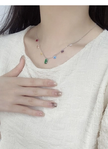 Detail view of a S925 silver necklace with rainbow cubic zirconia on a white shirt