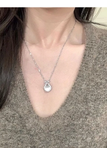 Close-up of S925 silver necklace featuring a translucent chalcedony bow pendant on neck