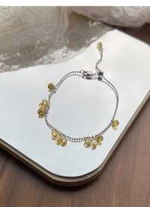 Detail of S925 silver pull-out bracelet featuring yellow teardrop crystals on a mirror