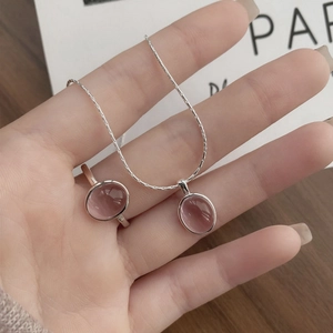 Elegant S925 silver necklace and ring set with oval pink gemstone held in hand