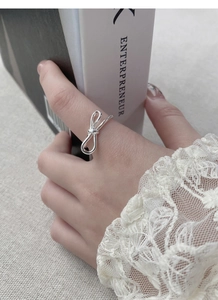 Macro detail of silver S925 bow ring featuring polished finish and adjustable open band