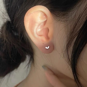 S925 sterling silver minimalist heart stud earring shown worn on a model's ear