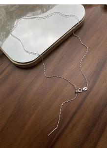 Detail of S925 sterling silver chain with adjustable bead and spring clasp on a mirror