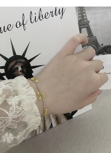 Detailed view of silver chain bracelet with yellow teardrop crystals on model's wrist