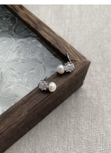 Macro detail of S925 sterling silver stamp on square zircon and freshwater pearl earrings