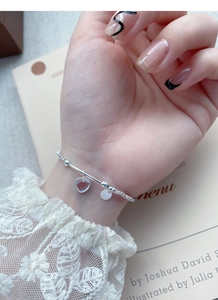 Detail eines Silberarmbands mit Herz-Mondstein am Handgelenk mit eleganter Spitze