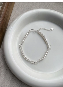Vue macro du bracelet en perles d'argent S925 avec nœuds et détail du fermoir coeur