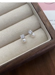 Macro shot of S925 sterling silver pearl stud earrings with square cubic zirconia settings