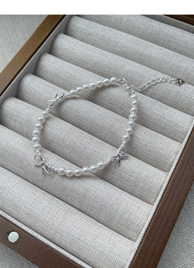 Détail du nœud en argent sterling S925 et des perles blanches sur le bracelet