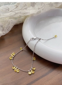 Detail of S925 sterling silver ball chain bracelet featuring yellow zircon gemstone drops