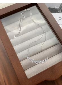 Macro shot of S925 sterling silver wisteria necklace with sparkling crystals in wood box