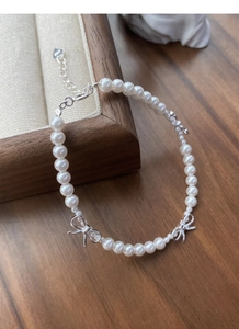 Détail du fermoir en argent S925 et du pendentif cœur sur un bracelet en perles