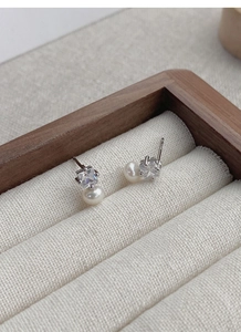 Macro shot of a square zircon and white freshwater pearl stud earring in a jewelry box