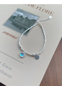 Detailansicht eines S925 Silberarmbands mit unregelmäßigen Perlen und Mondstein-Herzanhänger