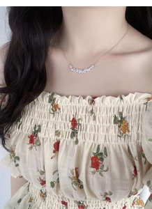 Close-up of S925 sterling silver wisteria necklace with sparkling zircon stones on model