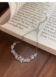 Detail eines S925 Sterling Silber Armbands mit Marquise-Zirkonia auf einem Buch liegend