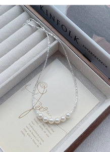 Close-up of S925 silver necklace featuring six lustrous pearls on a velvet jewelry tray