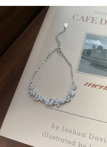 Makroaufnahme von S925 Sterlingsilber Blauregen Armband auf Vintage Buchseiten
