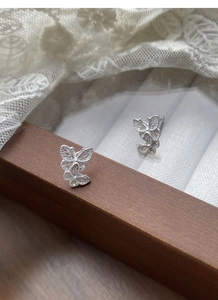 Macro shot of S925 sterling silver butterfly stud earrings with delicate hollow filigree
