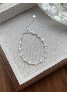 Macro detail of S925 silver bracelet with freshwater pearls and pink crystal beads