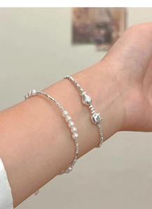 Close-up of S925 silver layered bracelets featuring pearls and cute cat and fish charms