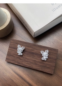 Close-up of S925 sterling silver butterfly studs showing intricate filigree craftsmanship